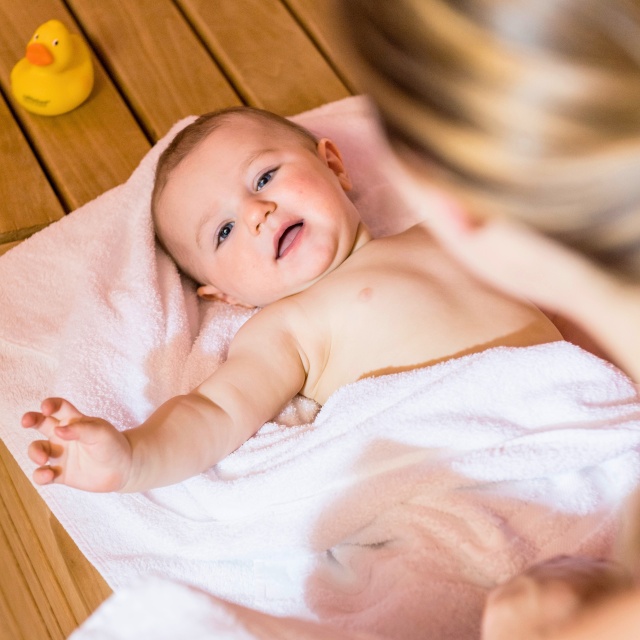 Baby liegt auf einem Handtuch.