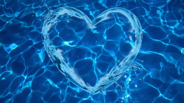 Wasserstrahlen in Herzform im dunkelblauen Wasser